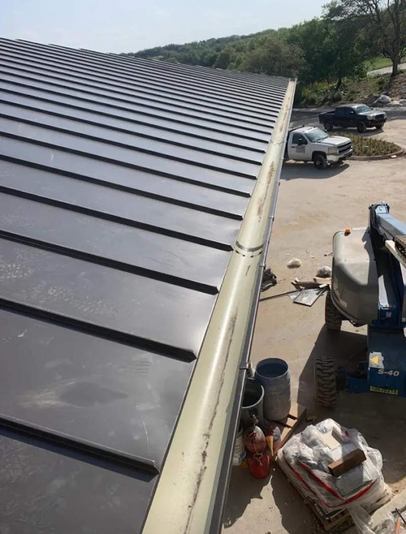 Standing seam panel and gutter detail on a metal roofing jobsite in Stonecrest